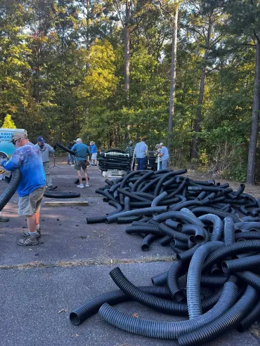 Group sorting black tubes in forest area