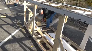 Man working on wooden structure outdoors