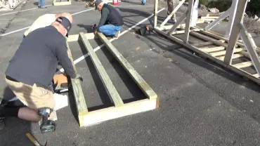 Men assembling wooden frames outdoors