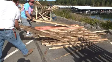 People stacking wooden planks outdoors