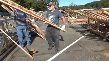 People moving construction materials in parking lot