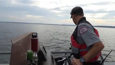 Officer navigating boat on calm waters