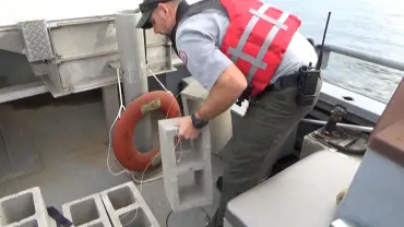 Worker on boat with cinder blocks