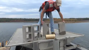 Man organizing blocks near water