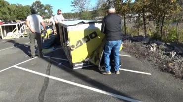 Team constructing a large yellow crate