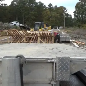 Worker organizing wooden beams at site