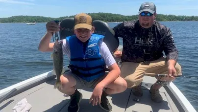 Man and boy fishing on lake boat