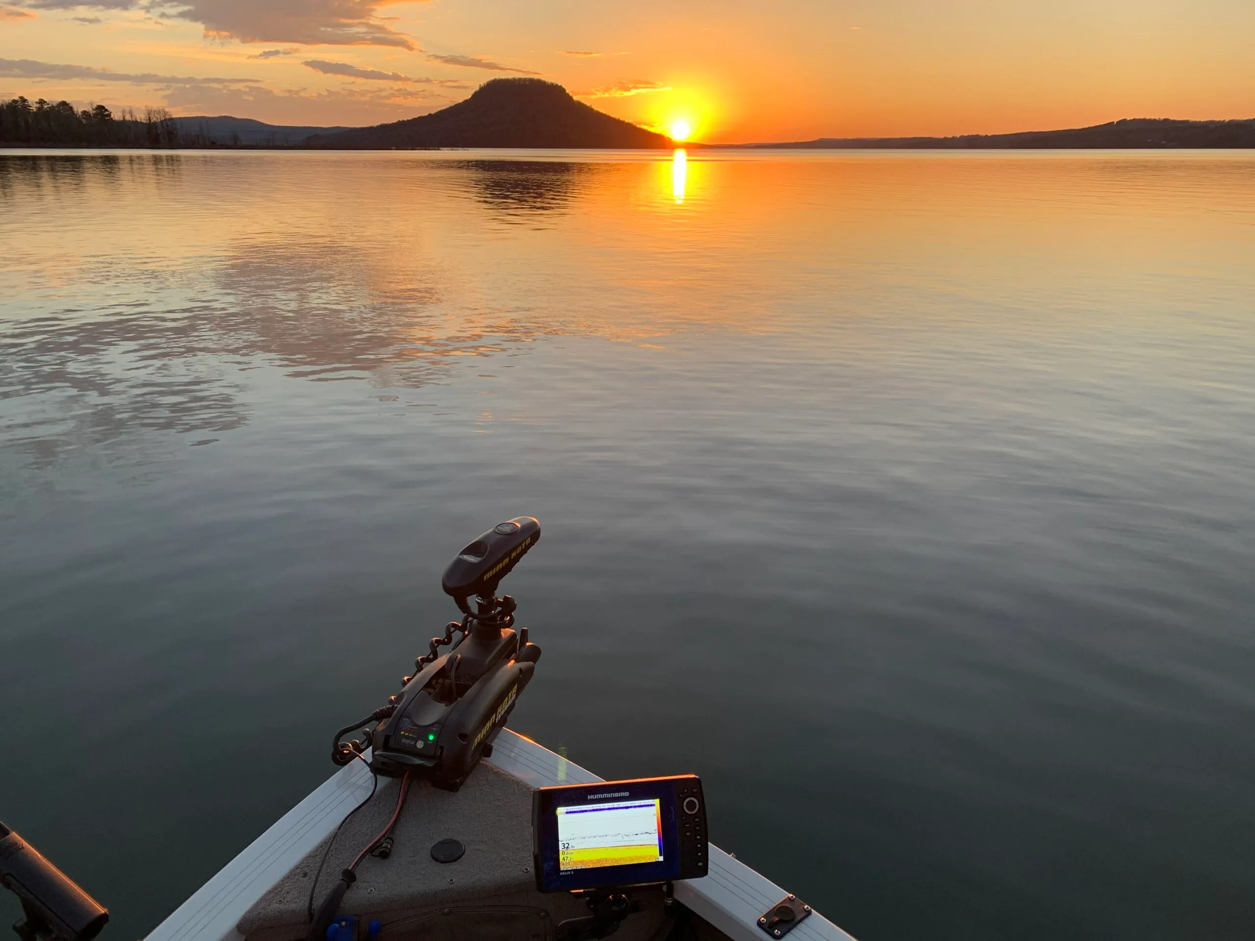 Boat on calm lake during sunset
