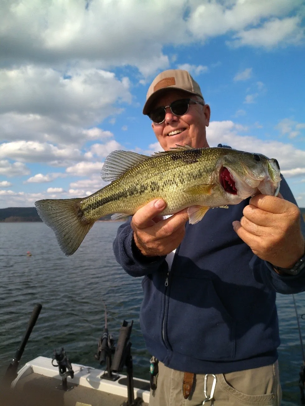 Fisherman displaying a catch on a lake