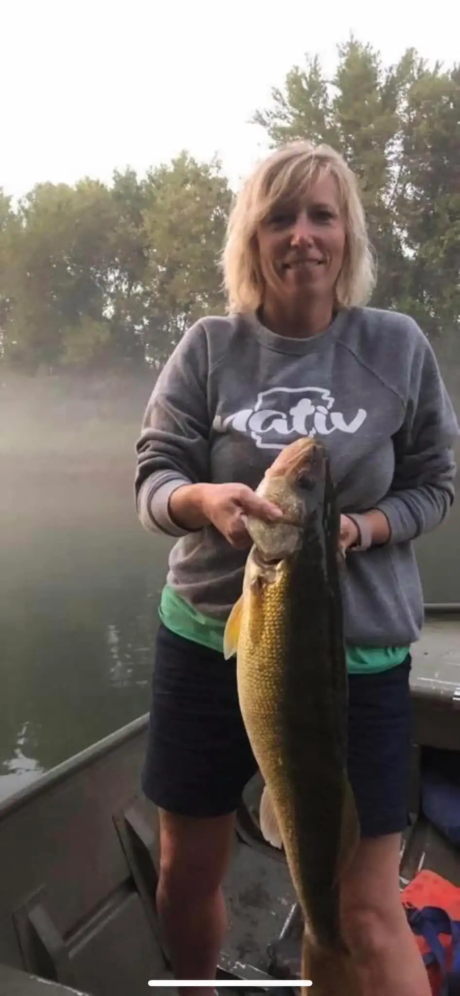 Woman holding large fish on a boat