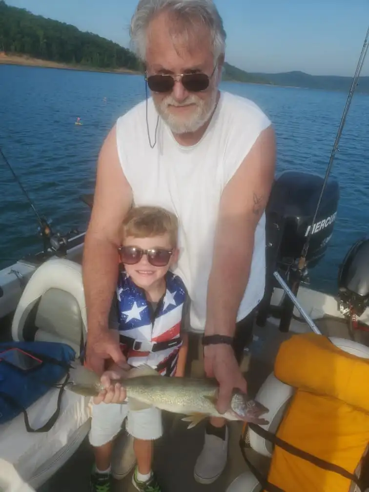 Grandfather and child holding a fish